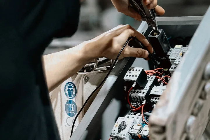 Technician maintaining a control panel