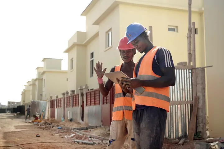 Workers in safety helmets and vests